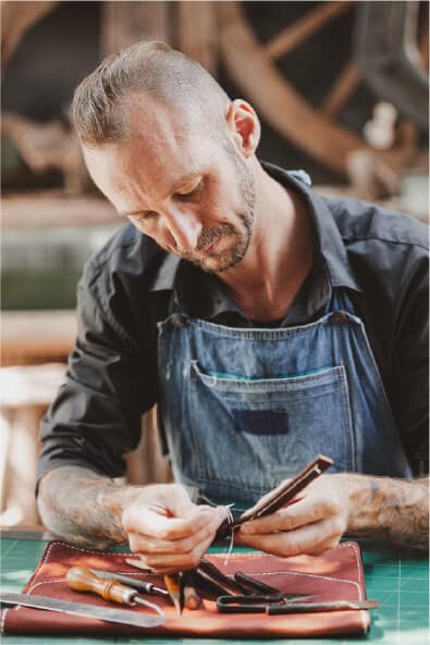 Artigiana sorridente mostra un manufatto in ceramica davanti al suo laboratorio
