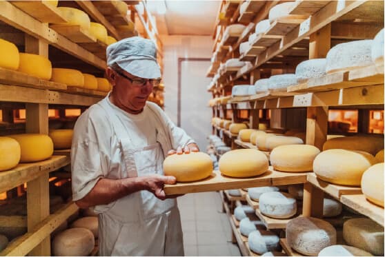 Artigiana sorridente mostra un manufatto in ceramica davanti al suo laboratorio