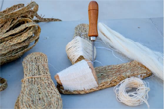 Artigiana sorridente mostra un manufatto in ceramica davanti al suo laboratorio